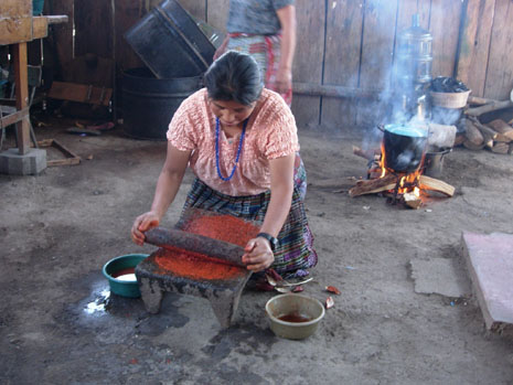 Grinding achiote with a mano and metate